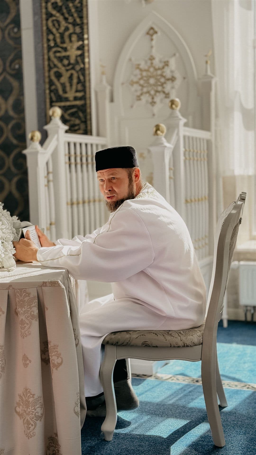 An imam conducting a nikah ceremony at a signing table